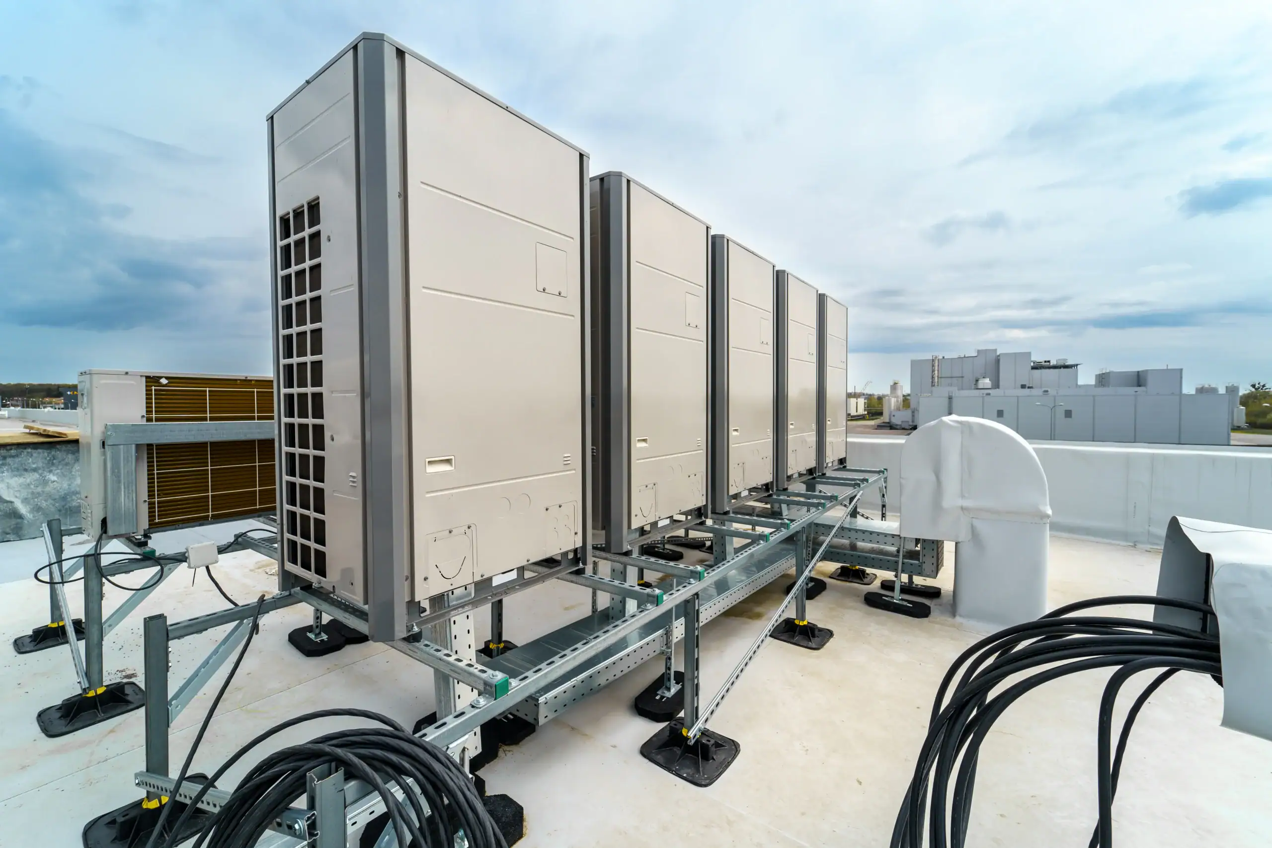 A group of metal boxes on a metal stand with Vehicle Assembly Building in the background.